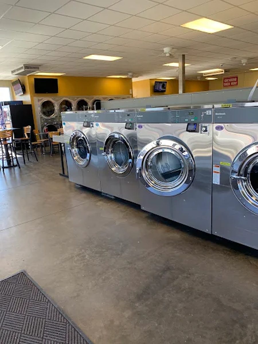 Rows of large-capacity washers and dryers at iWash Laundry